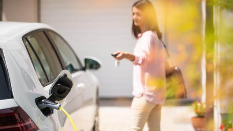 E-Auto Firmenwagen Ladestation Frau Title