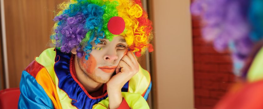 Trauriger Clown schaut in den Spiegel