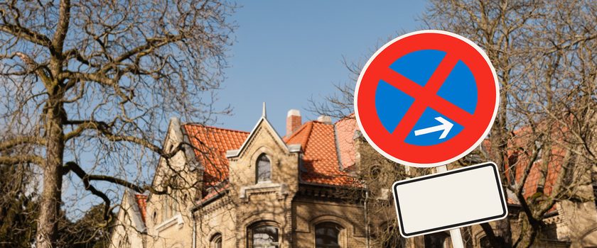 Schild mit absolutem Halteverbot vor Villa und Bäumen