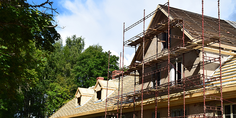 Ein altes Mehrfamilienhaus wird von außen renoviert.